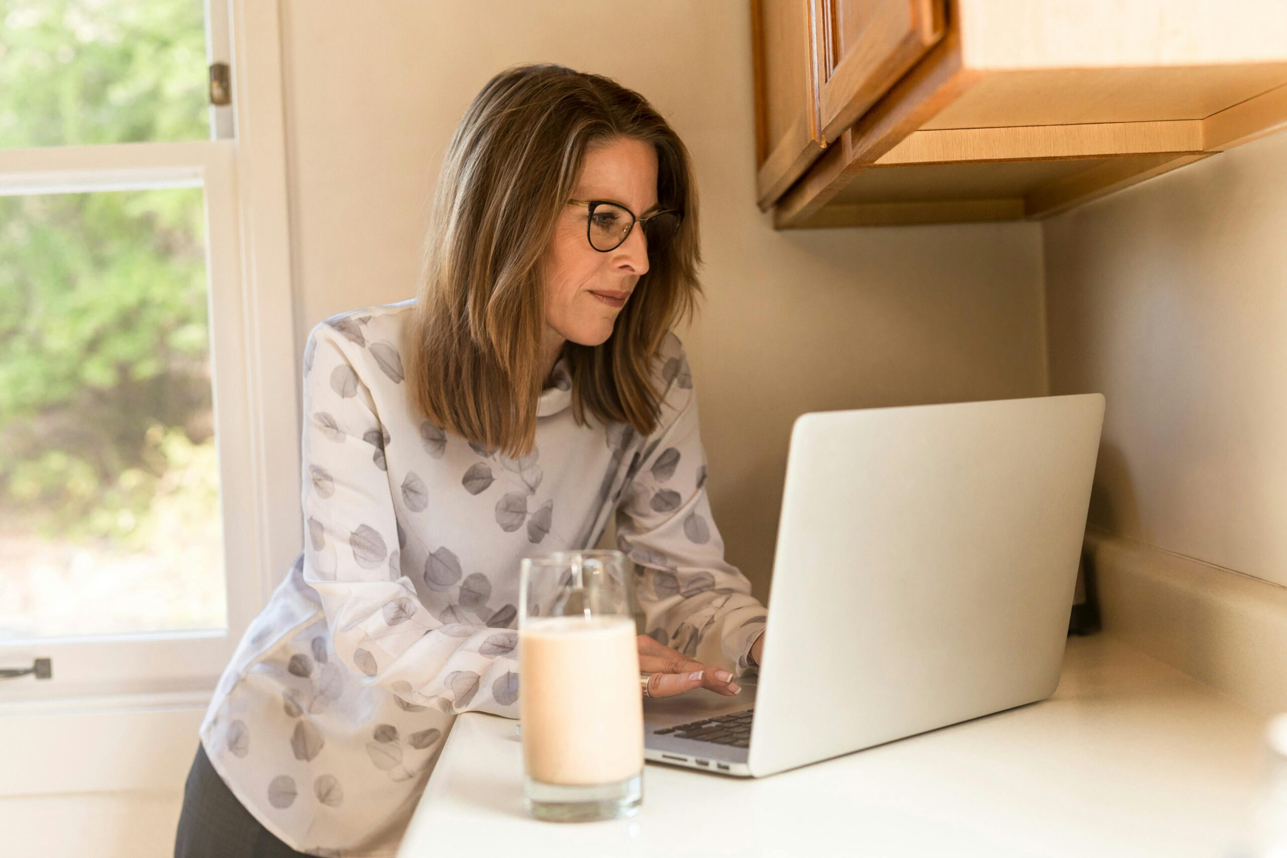a woman stands in kitchen learning how to get more done without working more hours